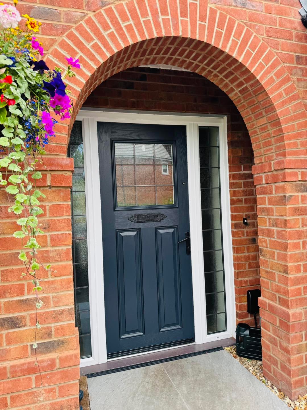 Navy front door framed by a brick arch