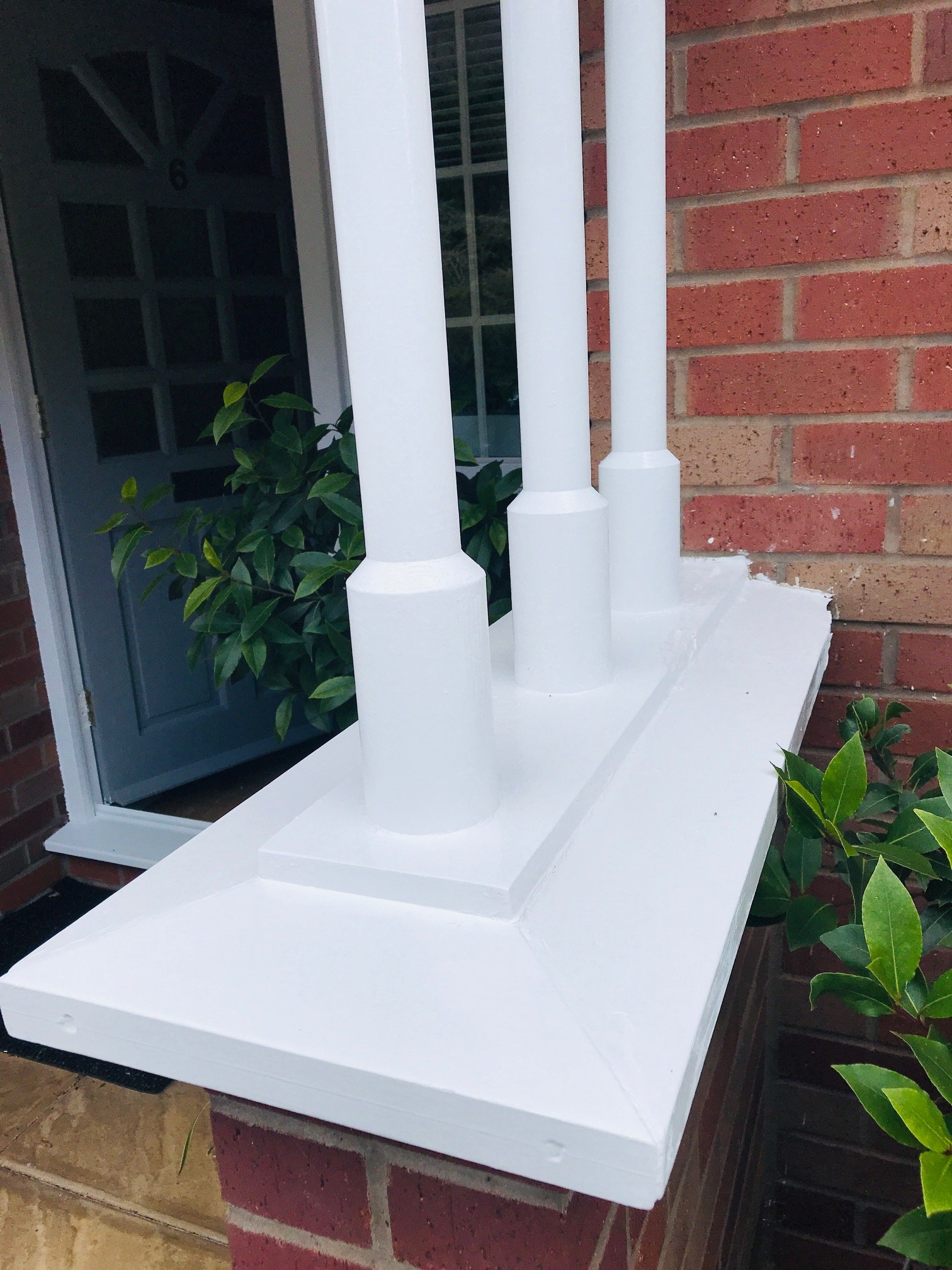 Porch columns painted bright white against red brick