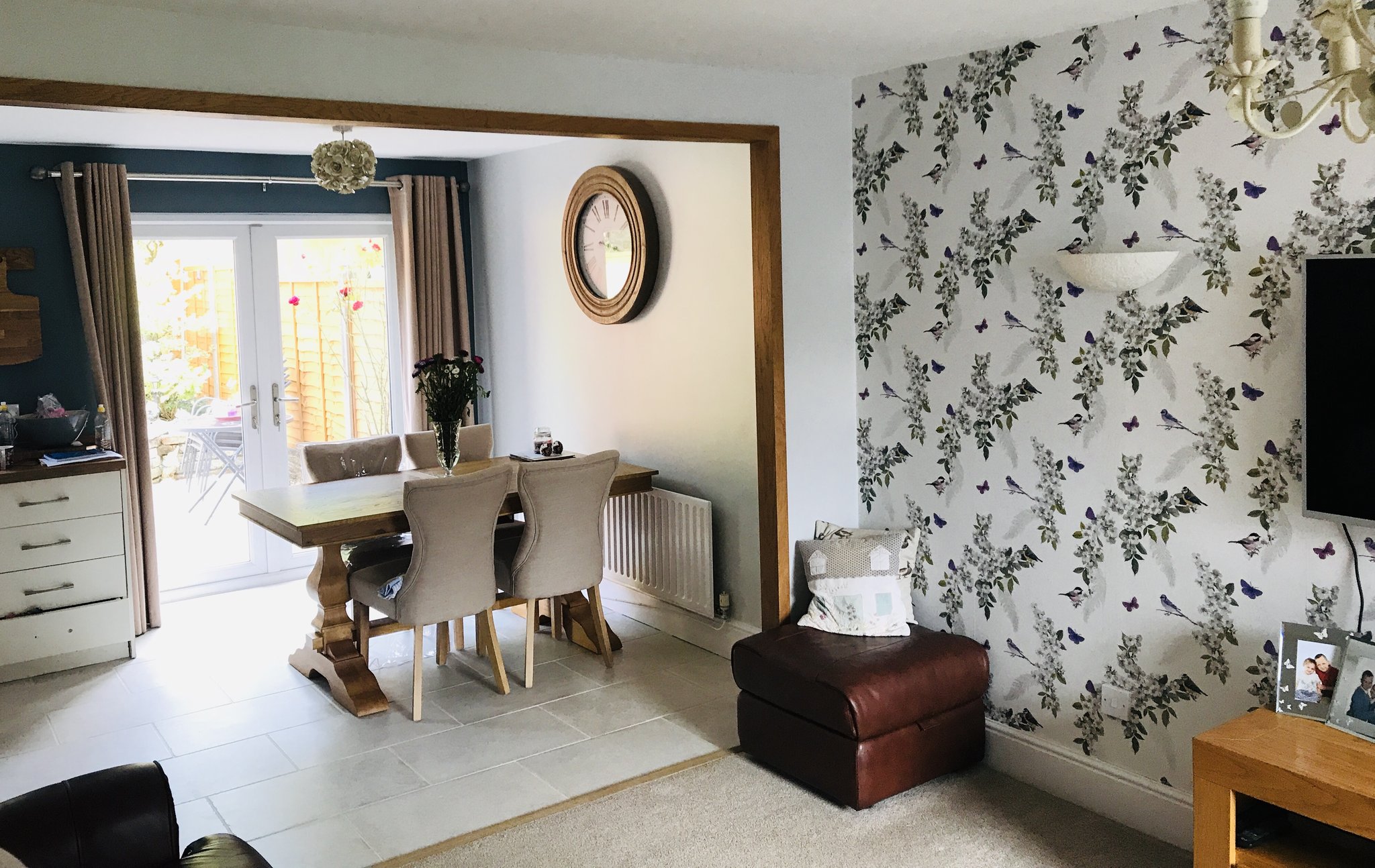 Open-plan dining room with floral feature wallpaper