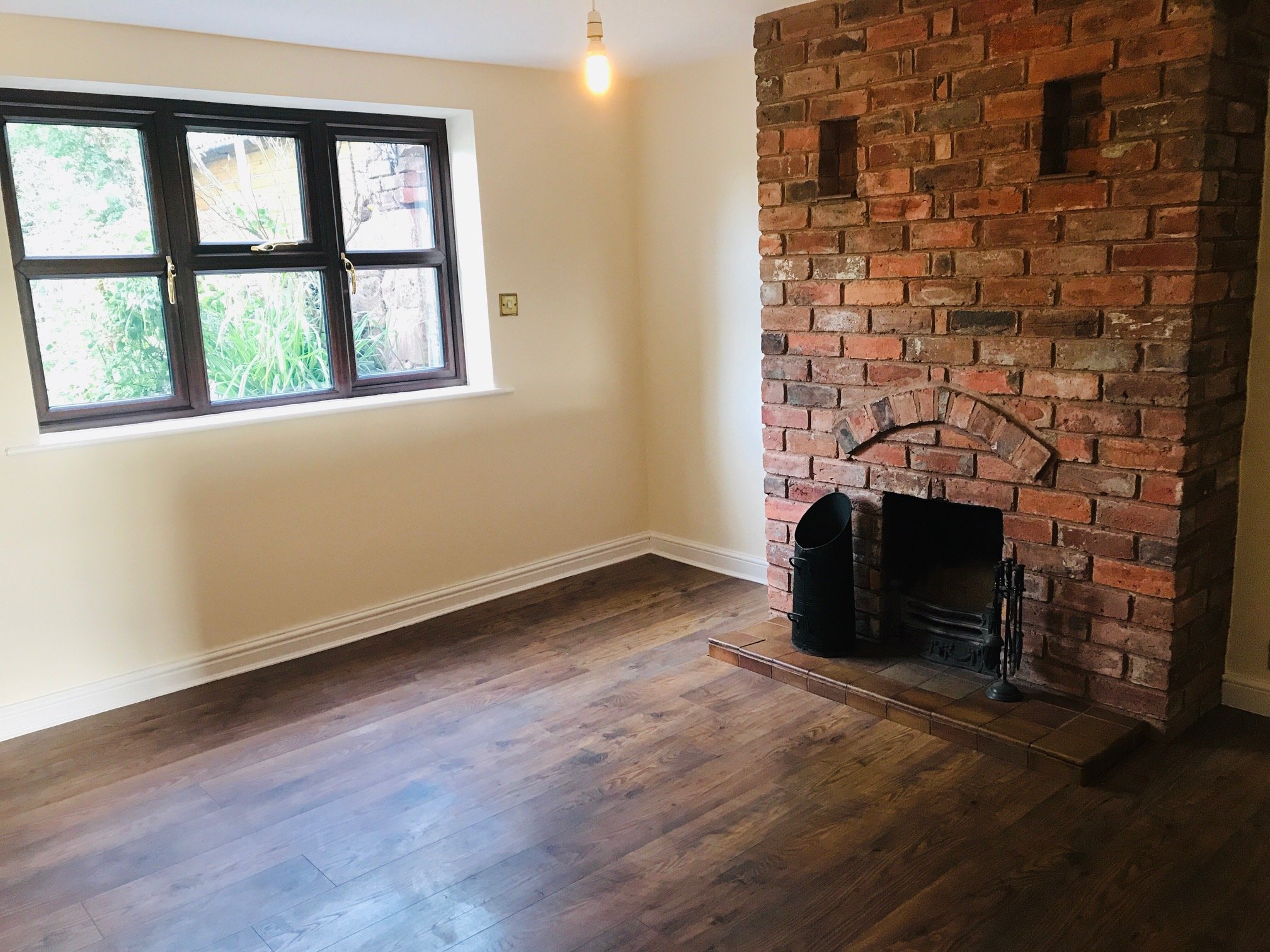 Cream room with a red-brick chimney breast
