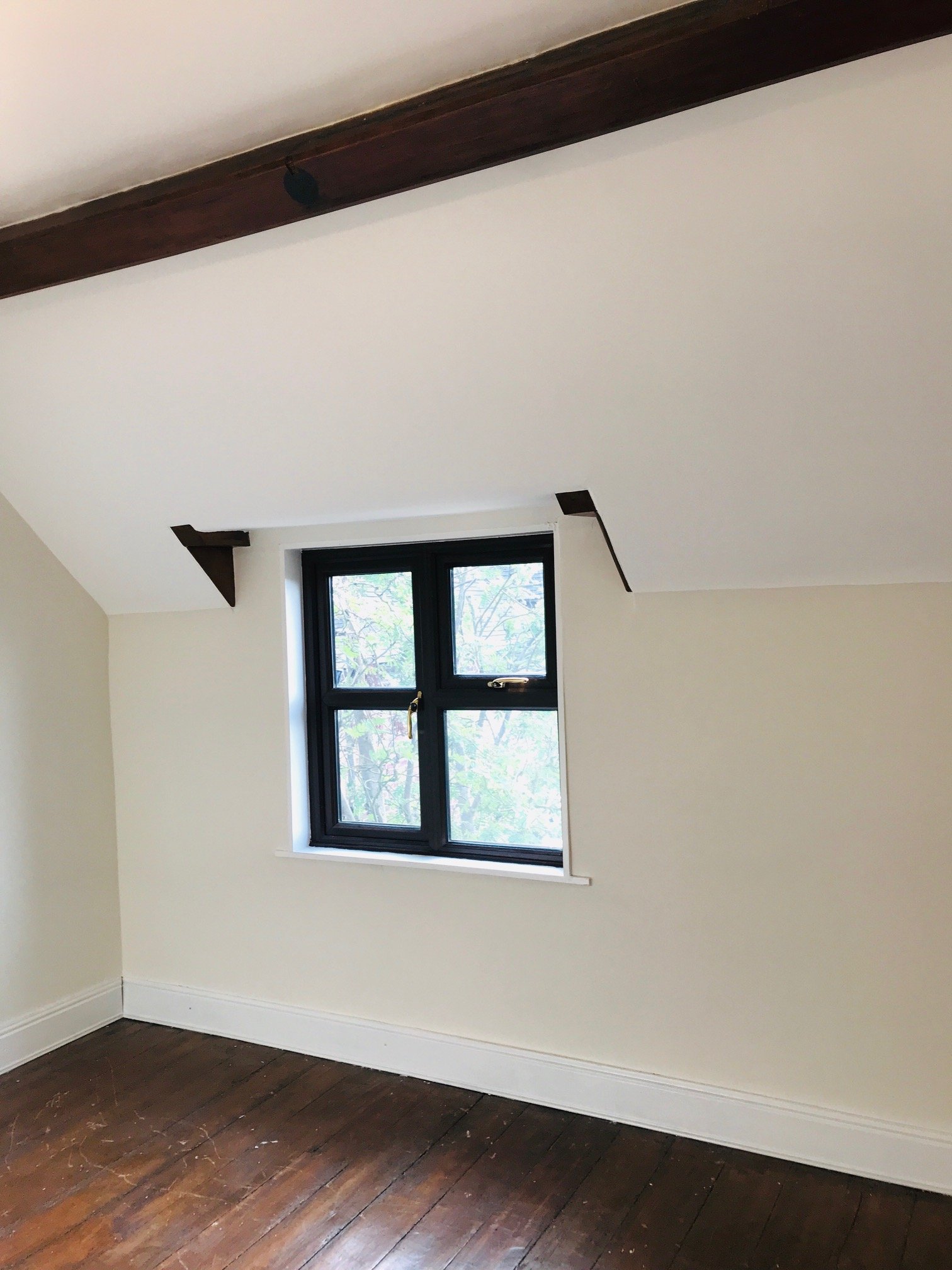 Attic room in cream with a dark oak beam